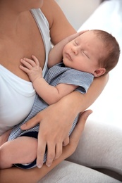 Photo of Young woman holding her baby near breast, closeup