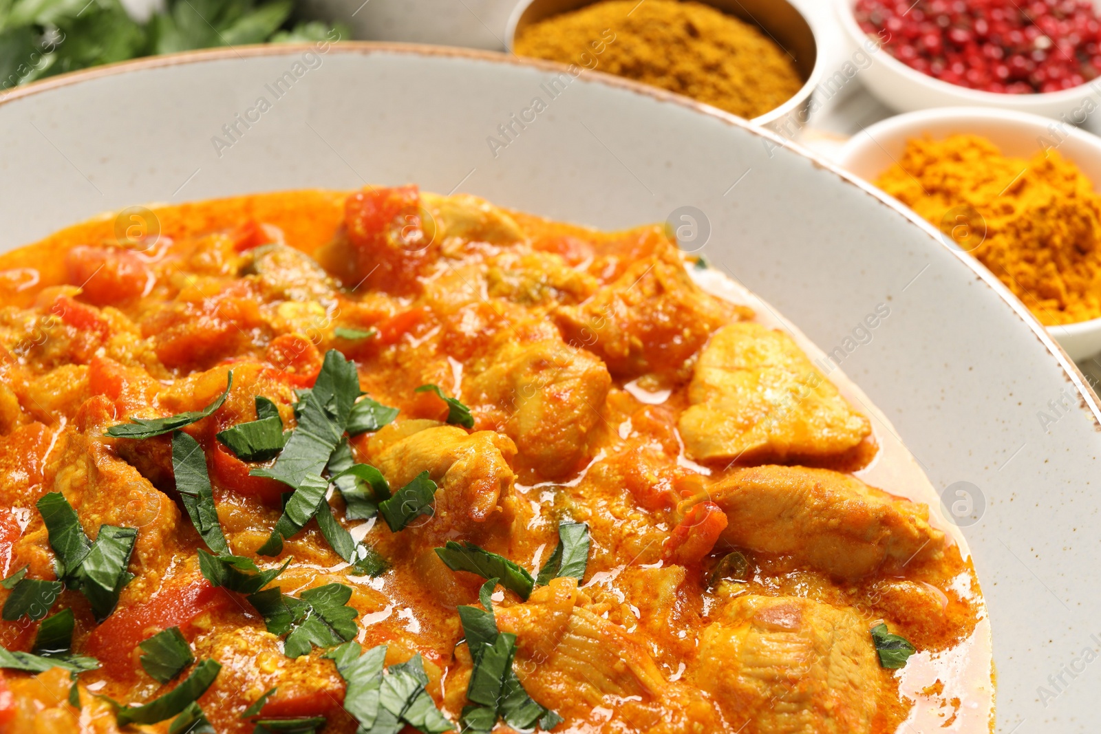 Photo of Delicious chicken curry with parsley on table, closeup