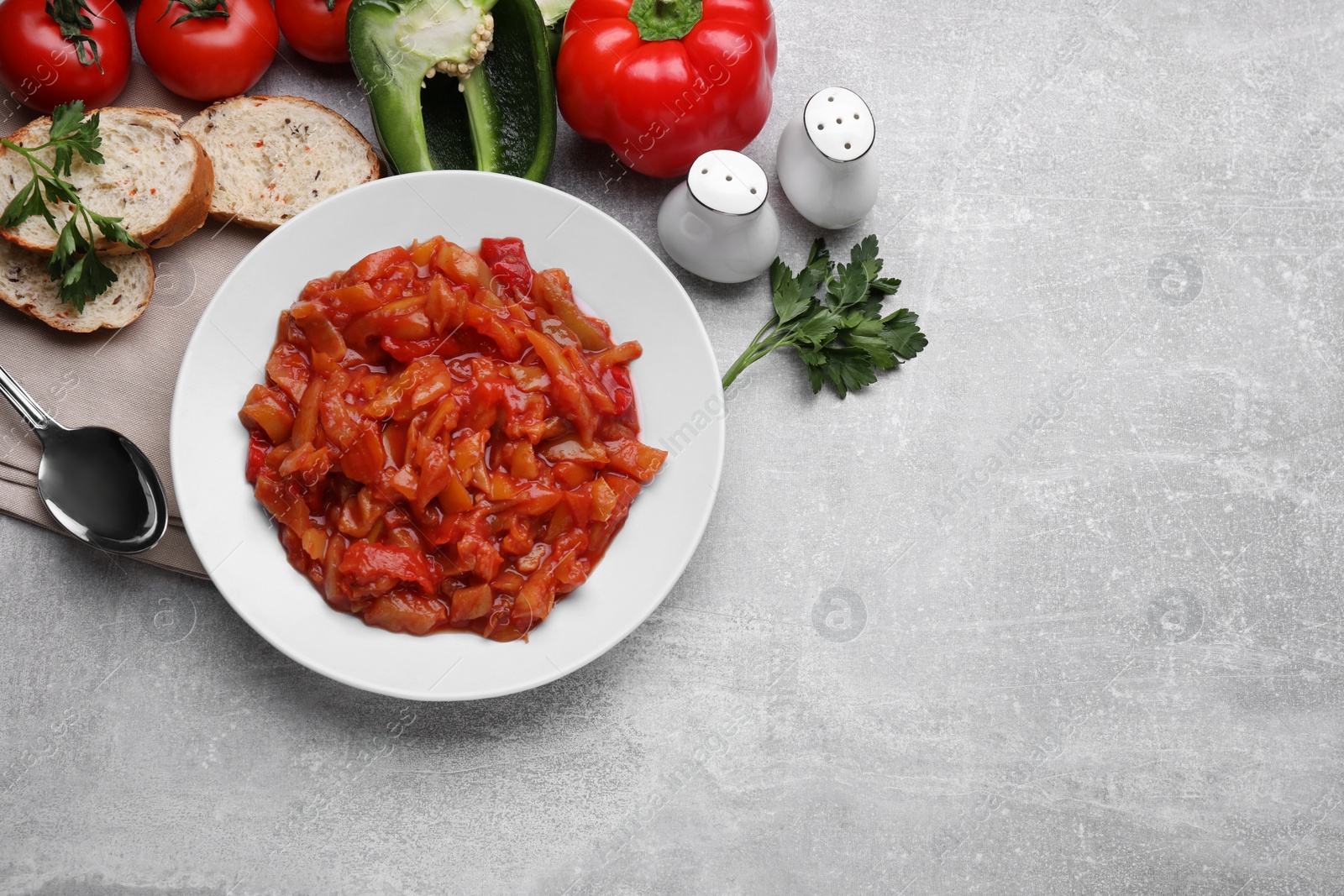 Photo of Delicious lecho and ingredients on light gray table, flat lay. Space for text