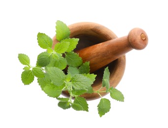 Wooden mortar with pestle and fresh green lemon balm leaves isolated on white, top view