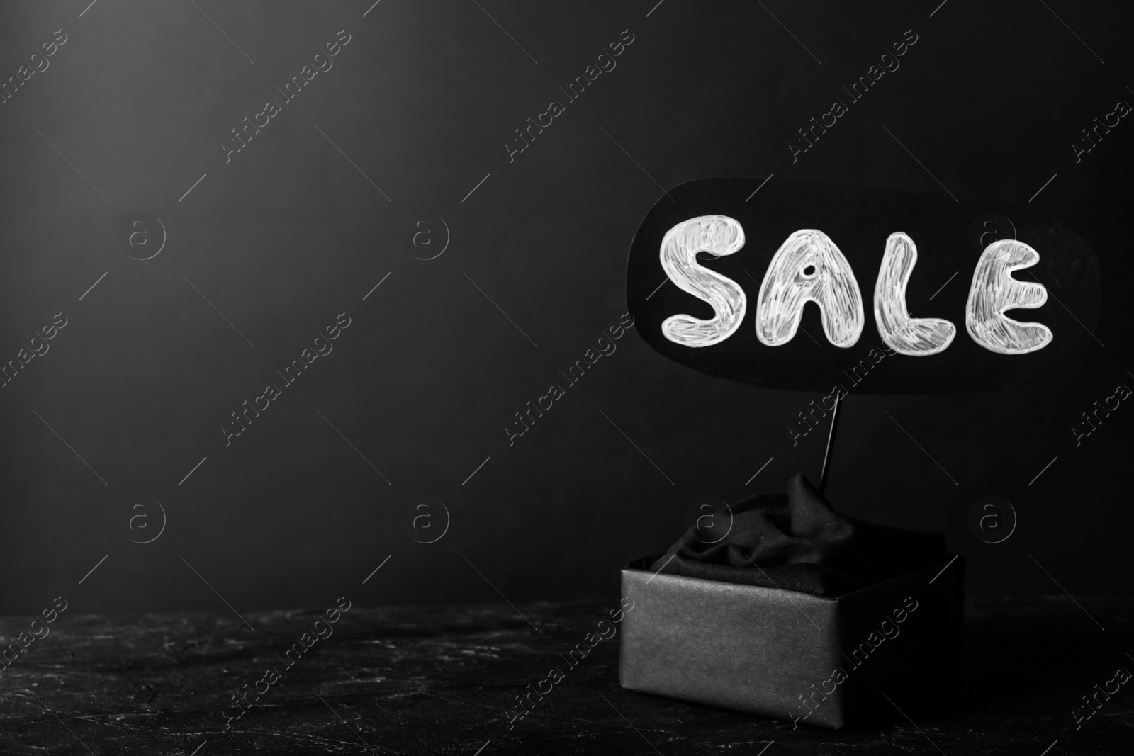 Photo of Package and card with word Sale on dark background, space for text. Black Friday concept