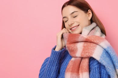 Photo of Beautiful woman in warm scarf on pink background, space for text