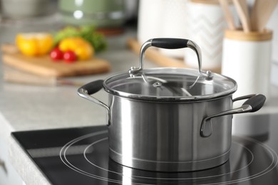 Photo of New shiny pot with glass lid in kitchen