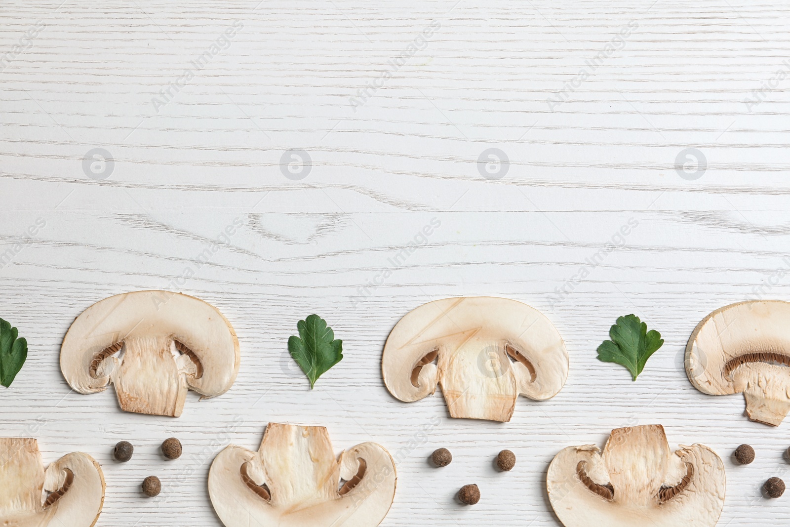 Photo of Sliced champignon mushrooms on wooden background, flat lay with space for text