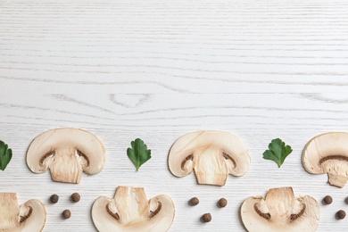 Photo of Sliced champignon mushrooms on wooden background, flat lay with space for text