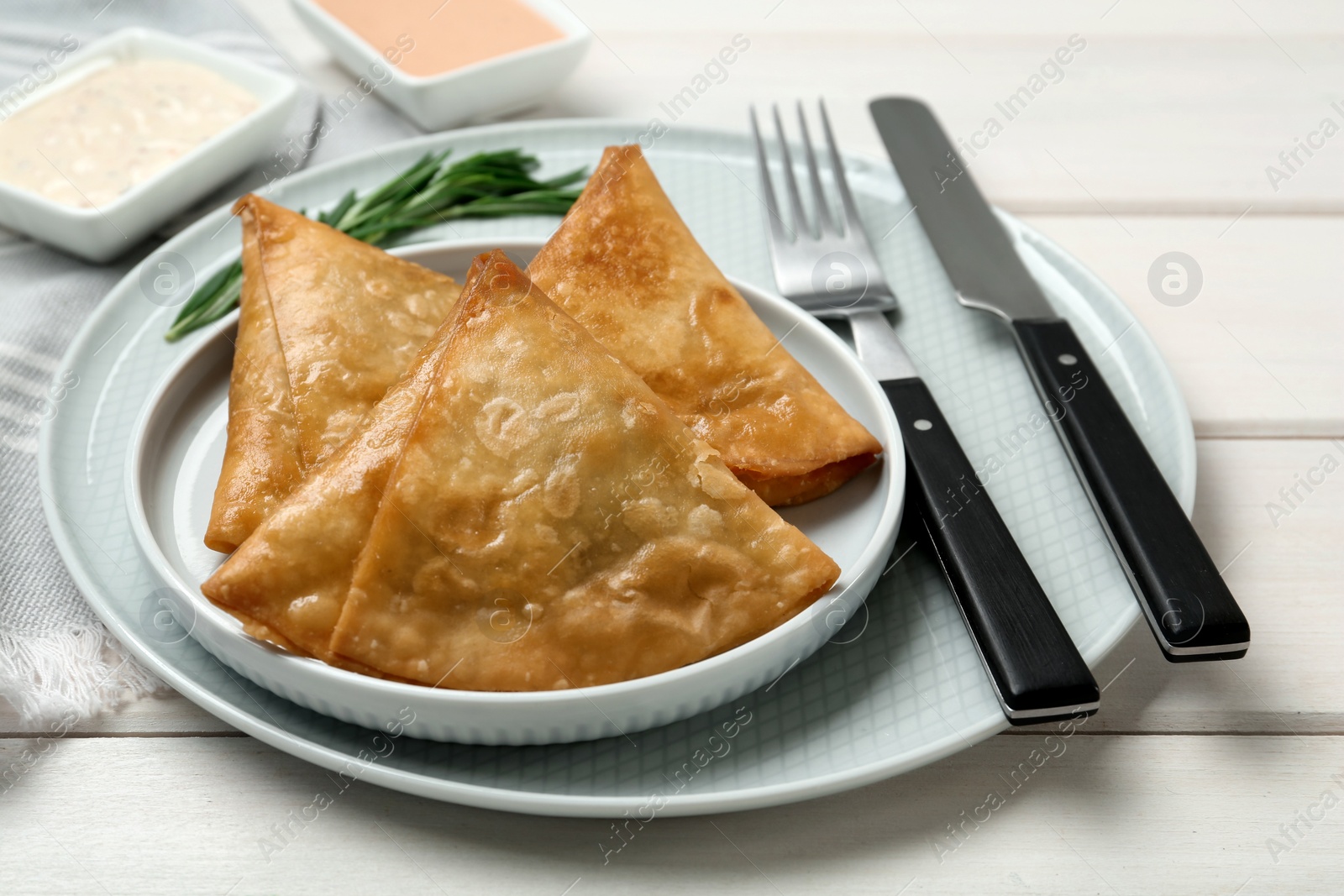 Photo of Fresh delicious crispy samosas served on white  wooden table