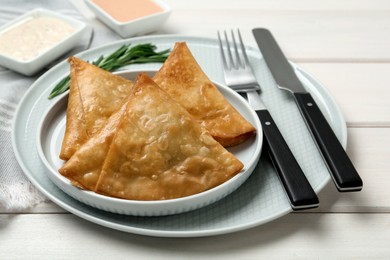 Fresh delicious crispy samosas served on white  wooden table