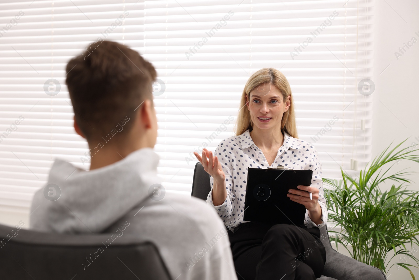 Photo of Psychologist working with teenage boy in office