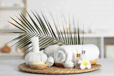 Composition with different spa products and plumeria flower on white table indoors