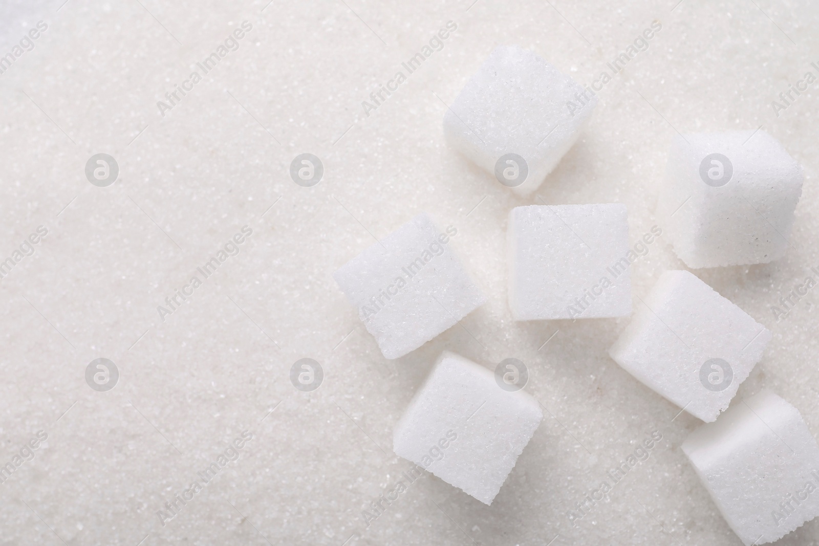 Photo of Different types of sugar as background, top view. Space for text