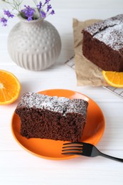 Photo of Piece of tasty chocolate sponge cake with powdered sugar on white table