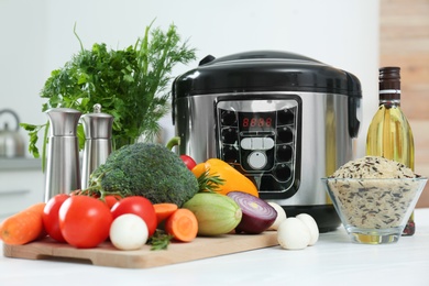 Modern multi cooker and products on kitchen table