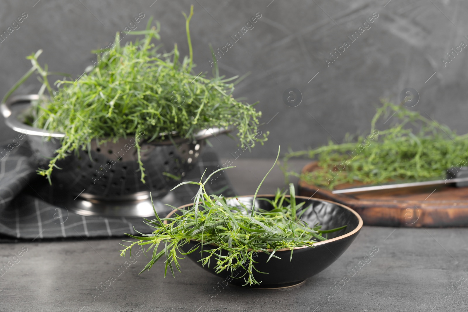 Photo of Fresh tarragon sprigs on grey table, space for text