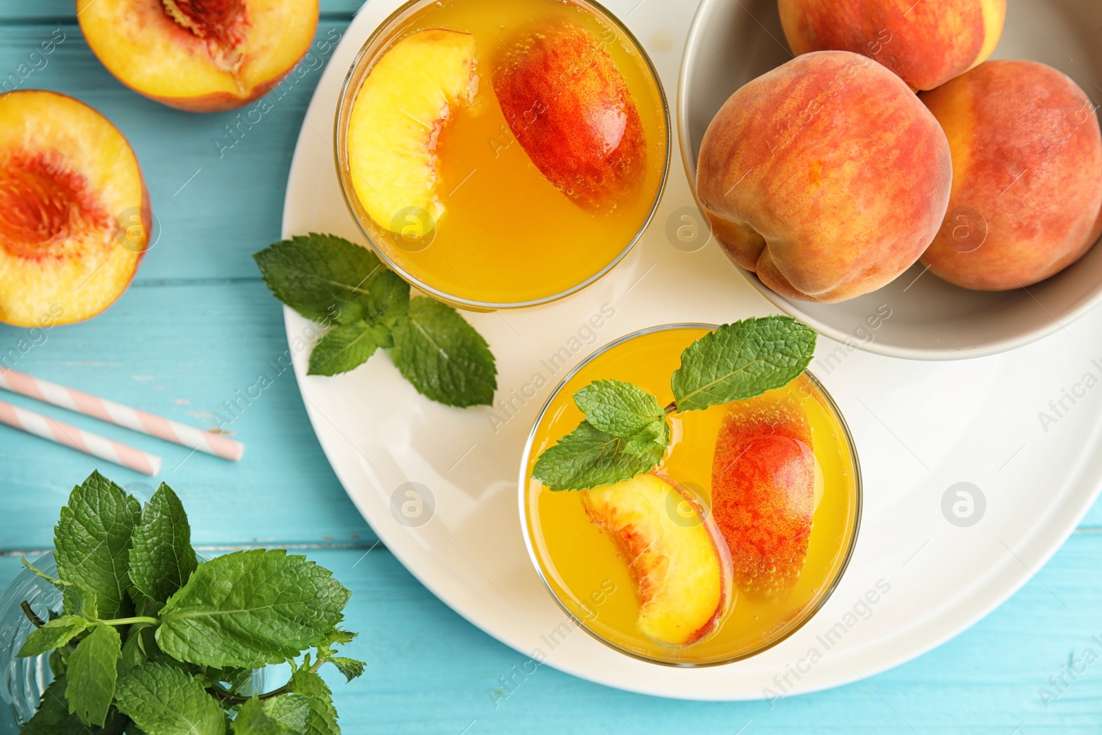 Photo of Tasty peach cocktail in glasses on table, top view. Refreshing drink