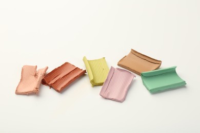Photo of Samples of different color correcting concealers on white background
