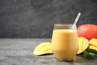 Fresh delicious mango drink on grey table. Space for text