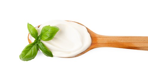 Wooden spoon with tasty mayonnaise and basil isolated on white, top view