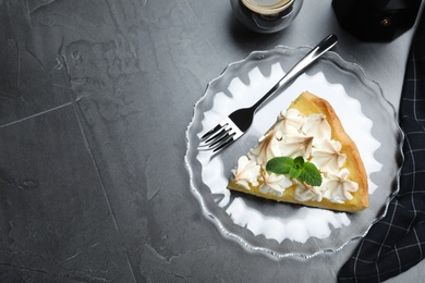 Photo of Piece of delicious lemon meringue pie with mint served on black table, flat lay. Space for text