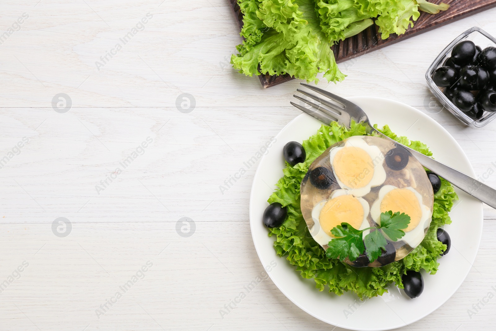 Photo of Delicious aspic with meat and vegetables served on white wooden table, flat lay. Space for text