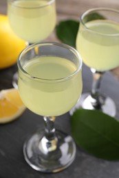 Photo of Tasty limoncello liqueur on table, closeup view