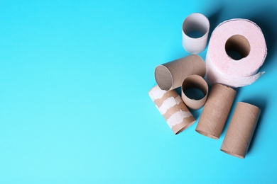 Photo of Toilet paper roll and empty tubes on color background. Space for text