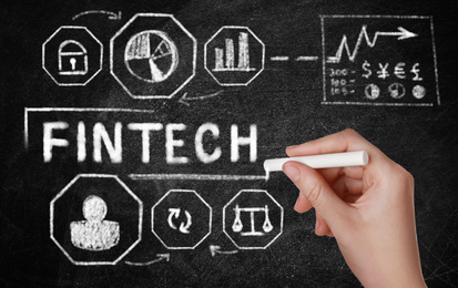 Image of Fintech concept. Woman drawing scheme with chalk on blackboard, closeup