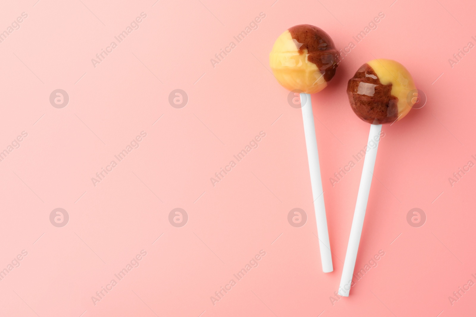 Photo of Tasty lollipops on pink background, flat lay. Space for text