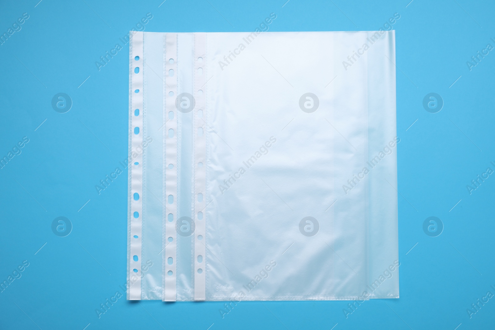 Photo of Punched pockets on light blue background, flat lay