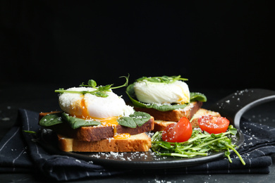 Photo of Delicious poached egg sandwiches served on slate board