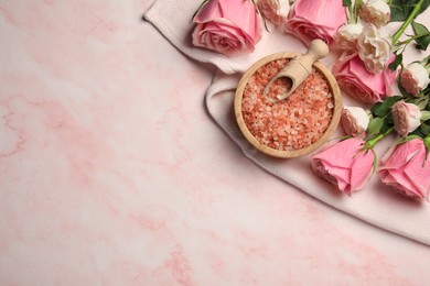 Aromatic sea salt and beautiful roses on pink marble table, top view. Space for text
