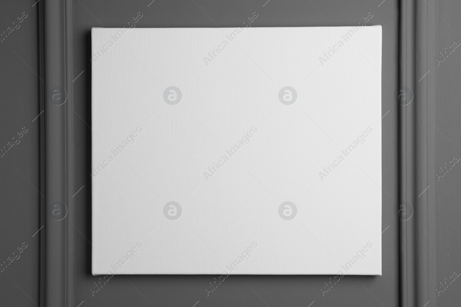 Photo of Blank canvas hanging on grey wall, space for text