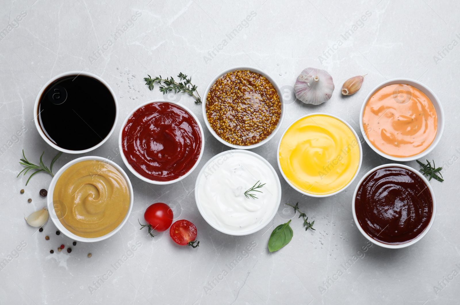 Photo of Many different sauces on light grey table, flat lay