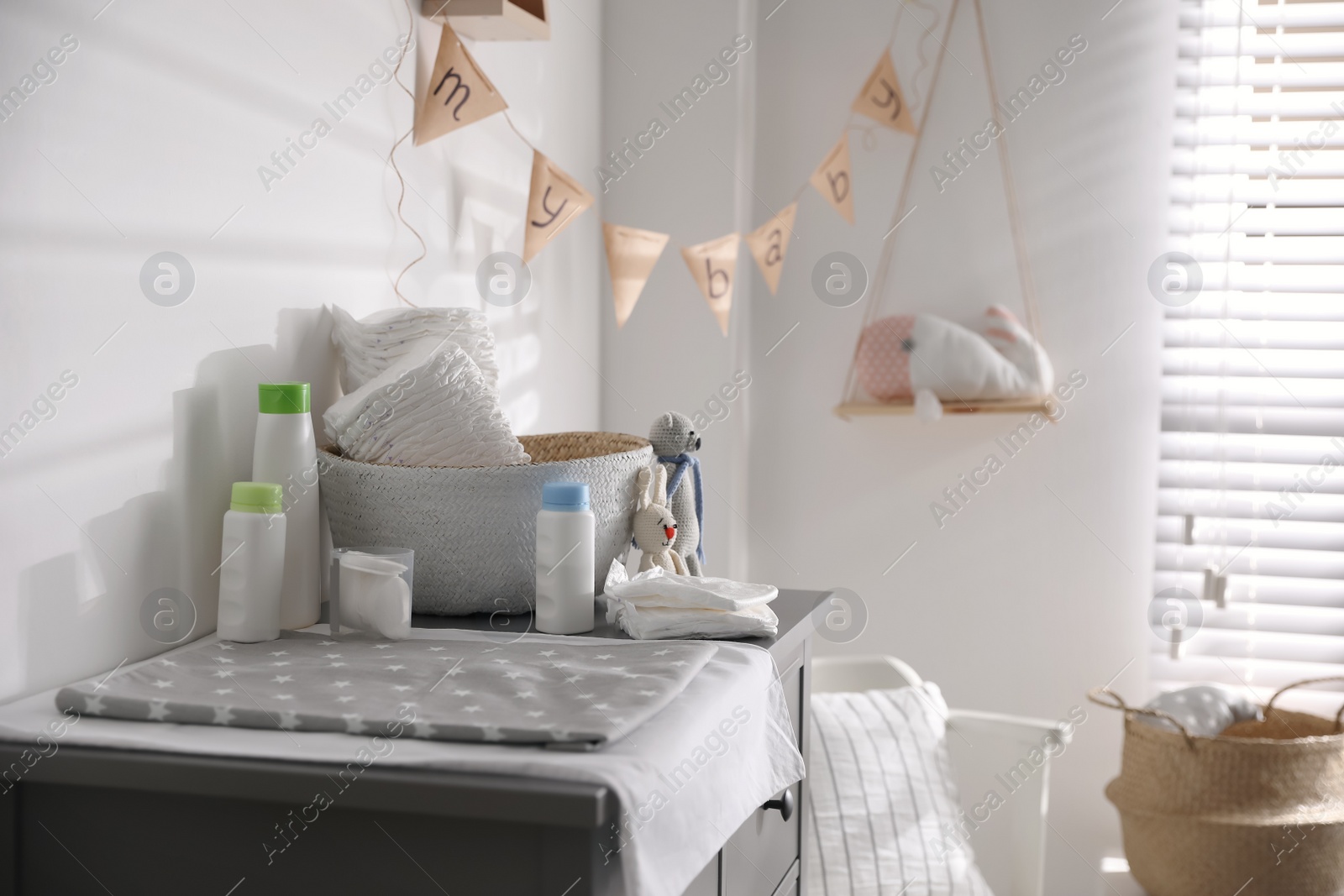 Photo of Chest of drawers with changing place in baby room. Interior design