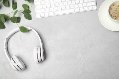 Photo of Flat lay composition with headphones, computer keyboard and space for text on grey background