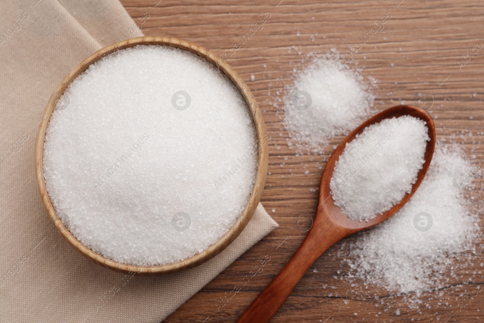 Photo of Granulated sugar on wooden table, flat lay