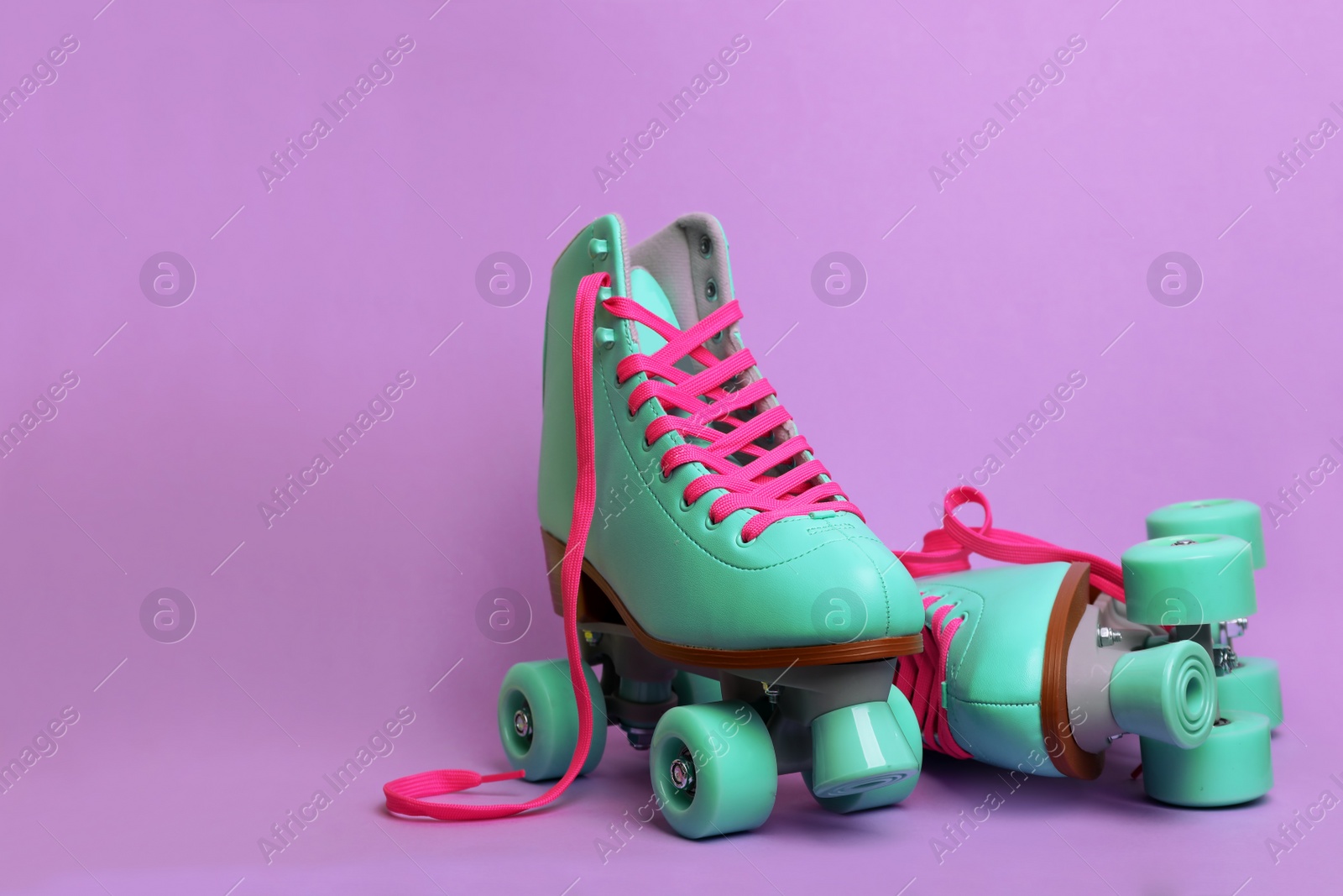 Photo of Pair of stylish quad roller skates on color background. Space for text