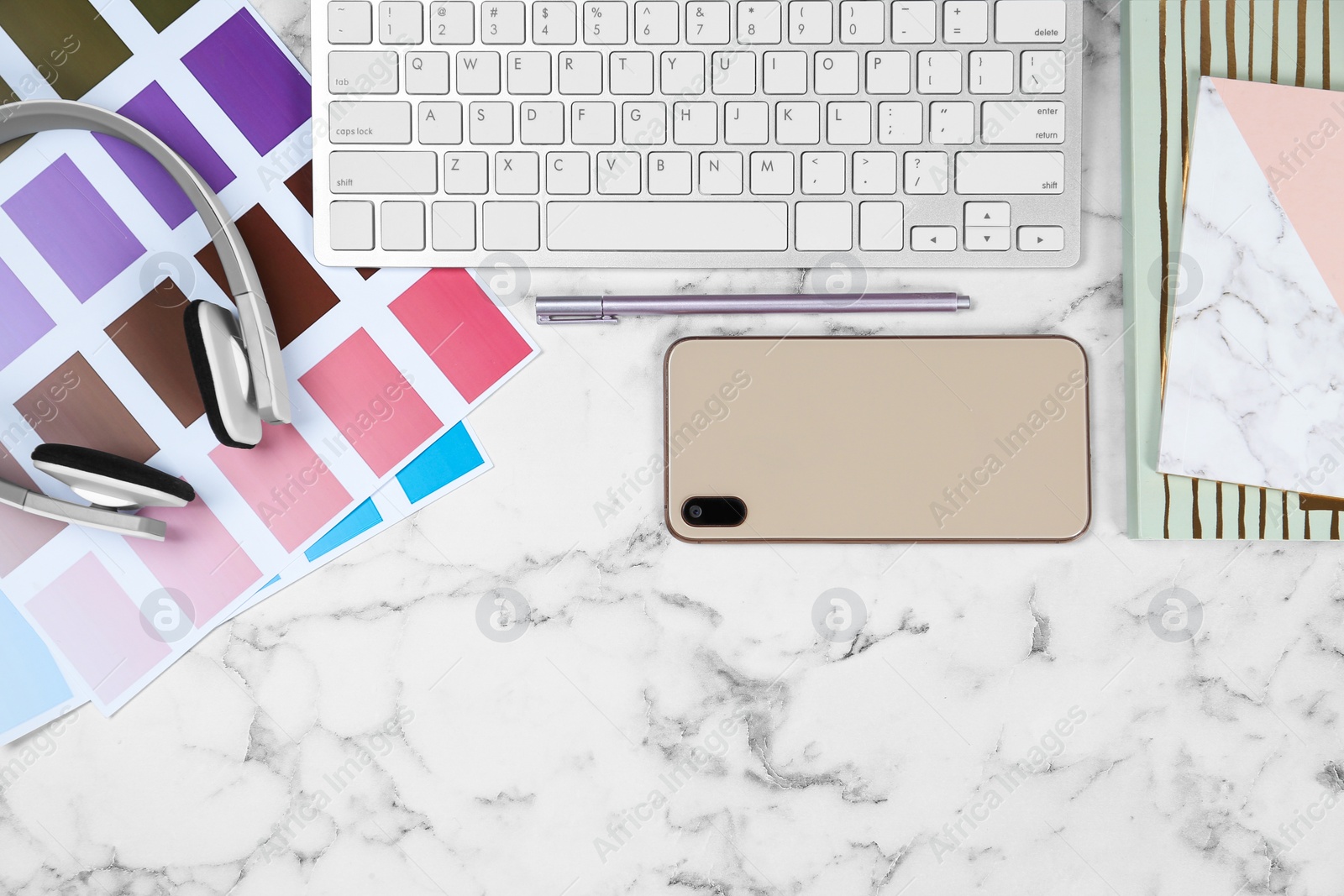 Photo of Flat lay composition with phone and color palettes on white marble table. Designer's workplace