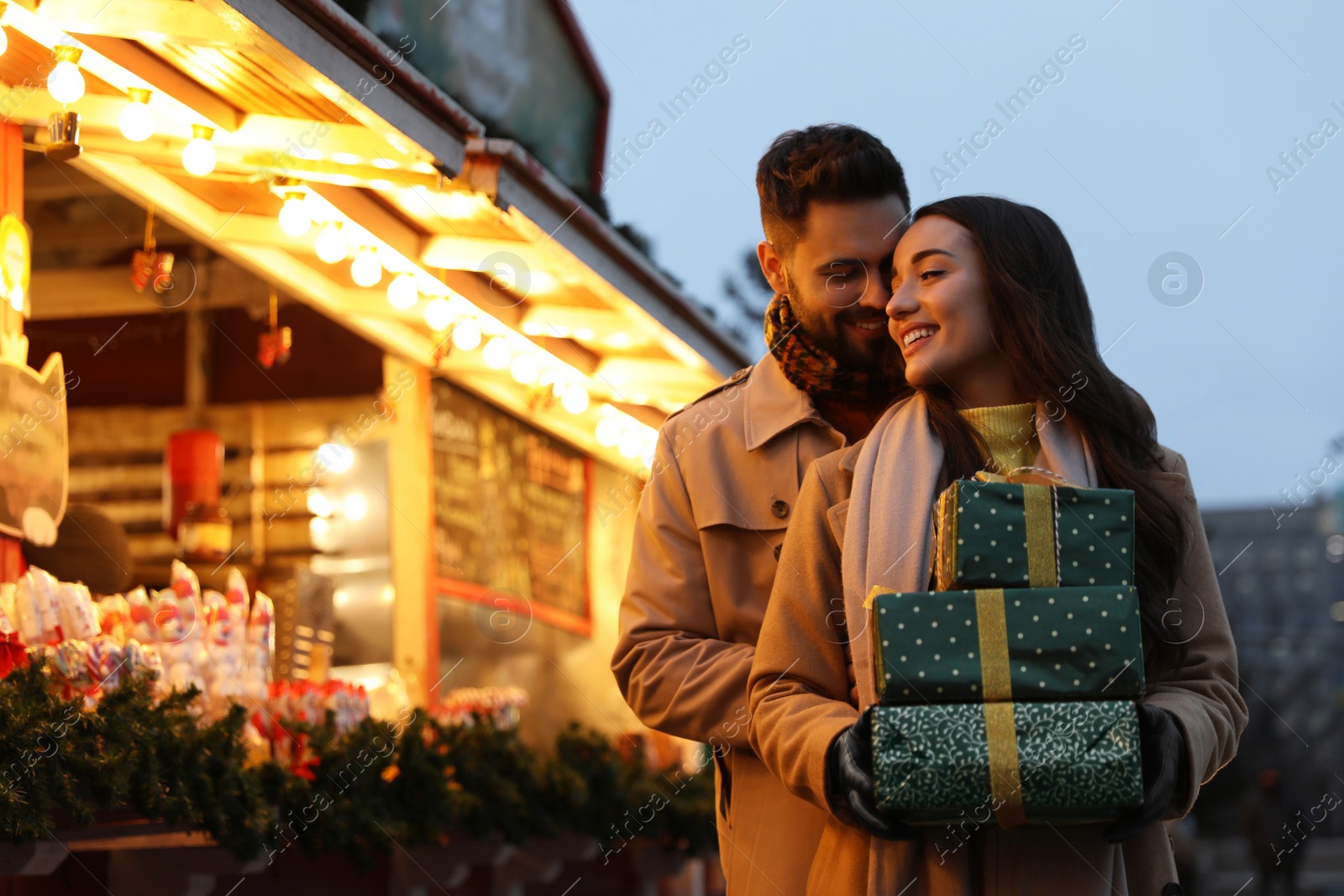 Photo of Lovely couple with Christmas presents at winter fair