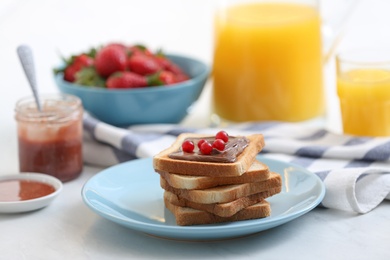 Toasted bread with chocolate spread and cranberries on white table in kitchen