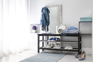 Photo of Cozy stylish hallway interior with shoe rack and mirror, space for text. Home design idea