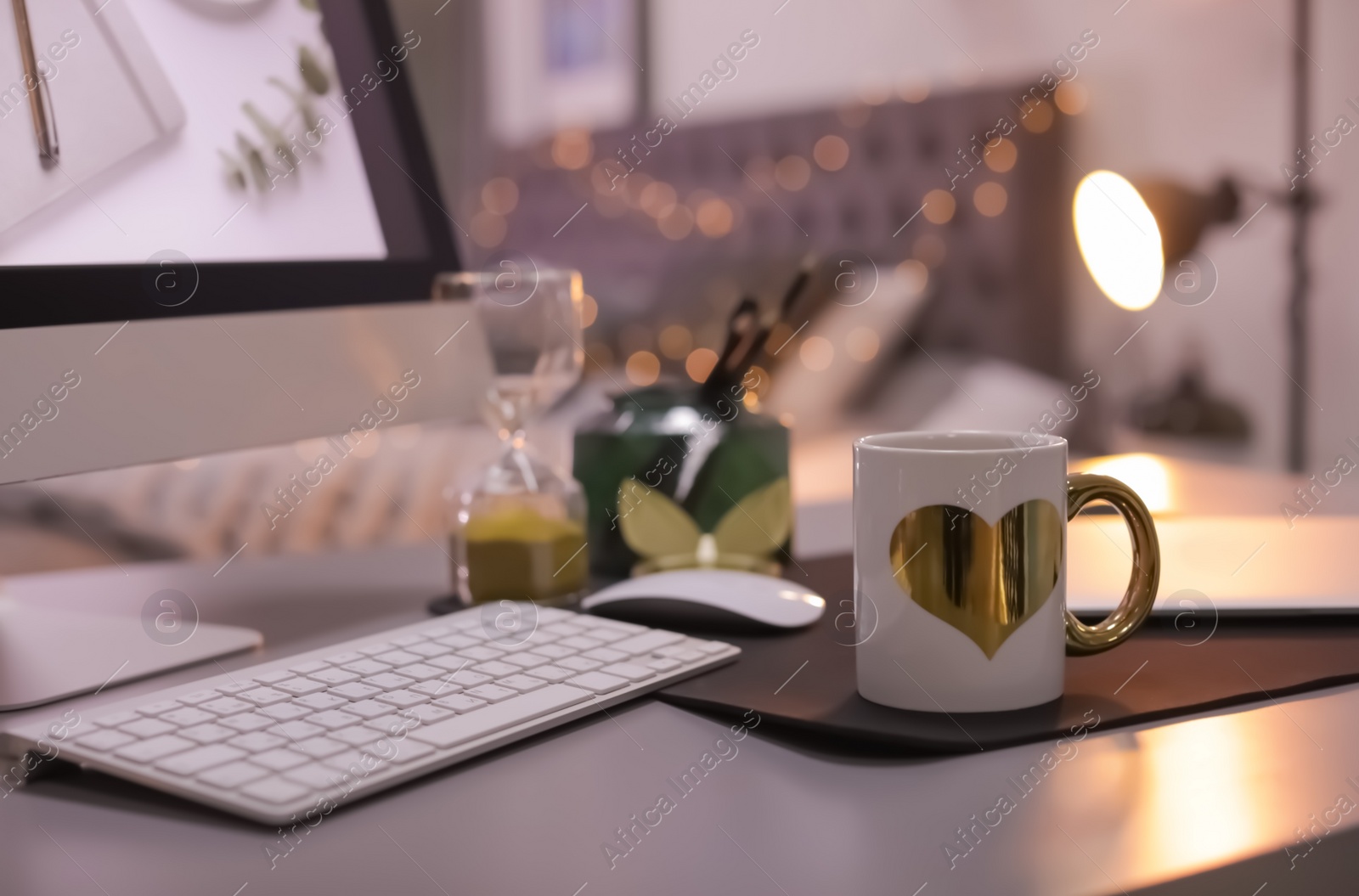 Photo of Stylish workplace with modern computer on desk. Focus on cup of drink