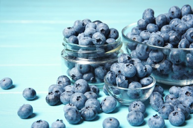 Photo of Glassware with juicy and fresh blueberries on wooden table