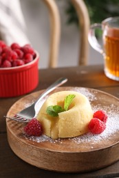 Tasty vanilla fondant with white chocolate and raspberries on table