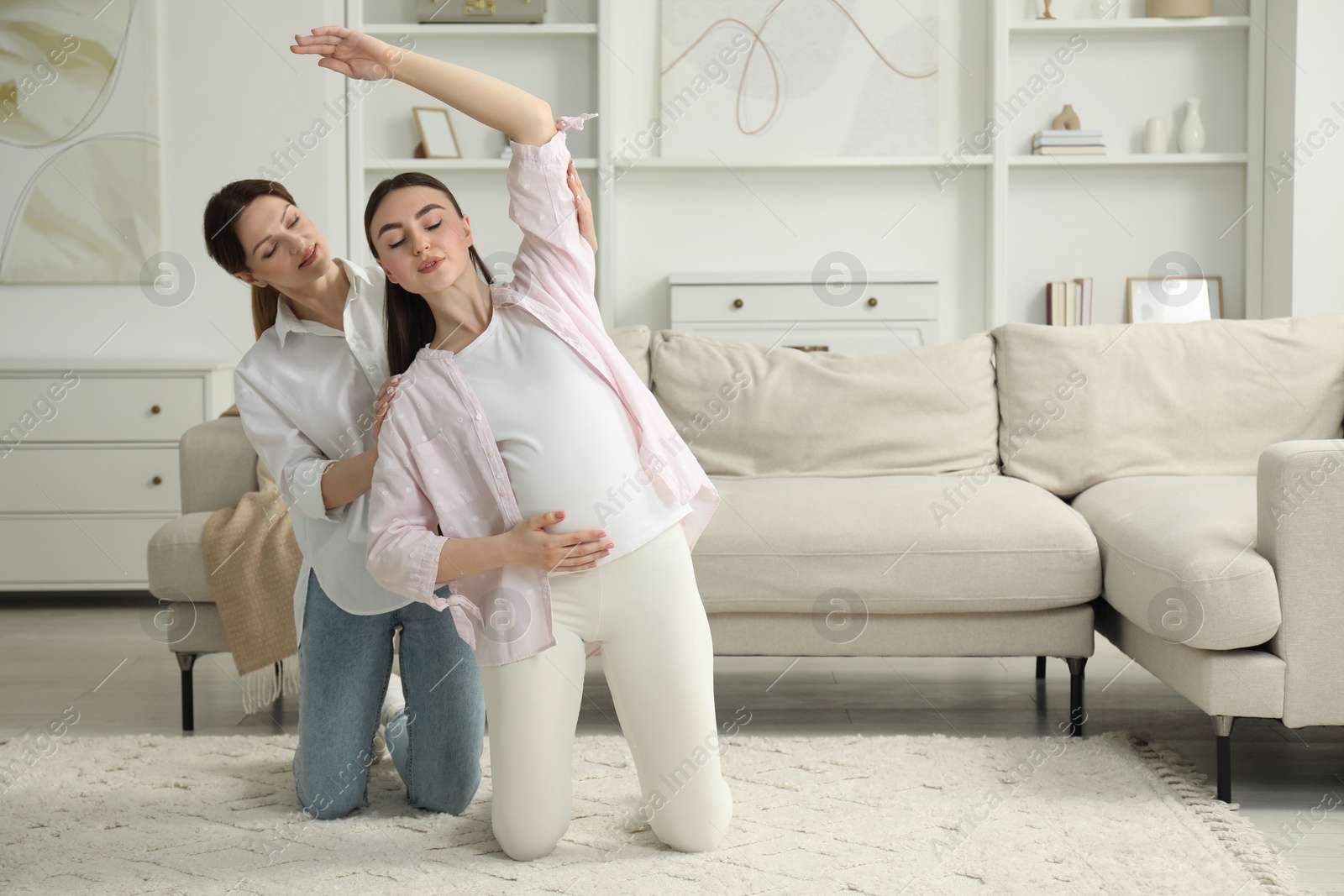 Photo of Doula working with pregnant woman at home. Preparation for child birth