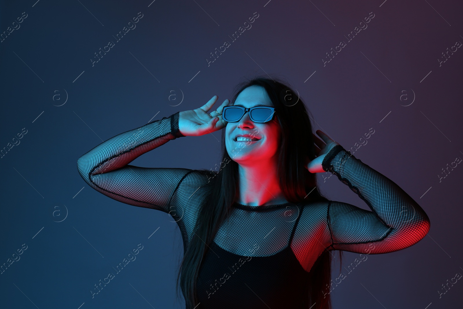 Photo of Portrait of beautiful young woman with sunglasses on color background