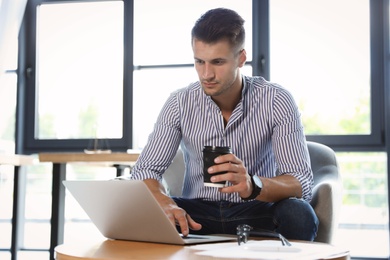 Male business trainer working with laptop in office