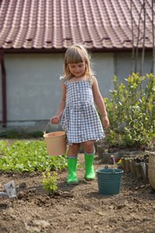 Cute little girl spending time in garden on spring day