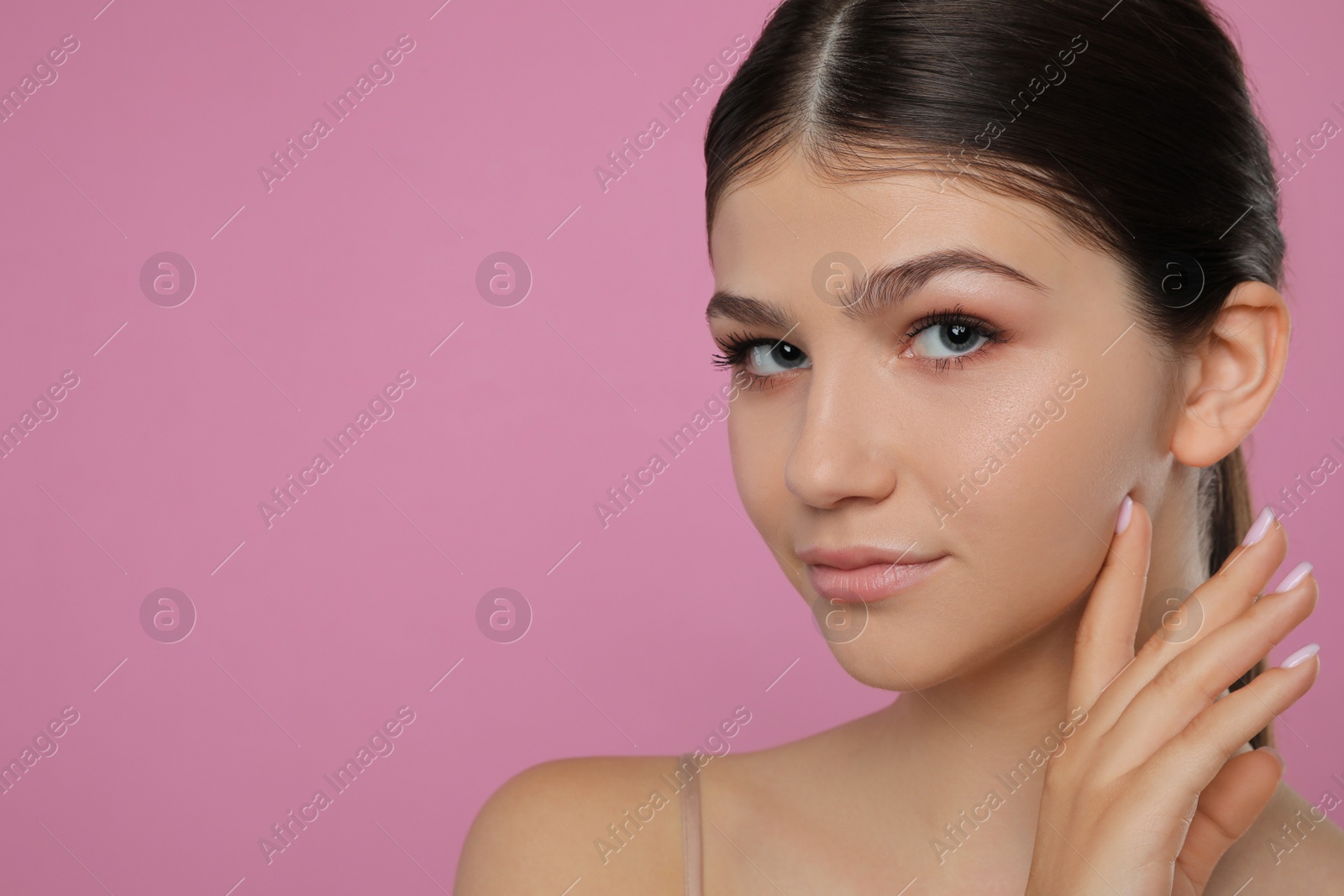 Photo of Pretty girl on pink background, space for text. Beautiful face with perfect smooth skin