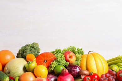 Photo of Assortment of fresh organic fruits and vegetables on light background, closeup. Space for text