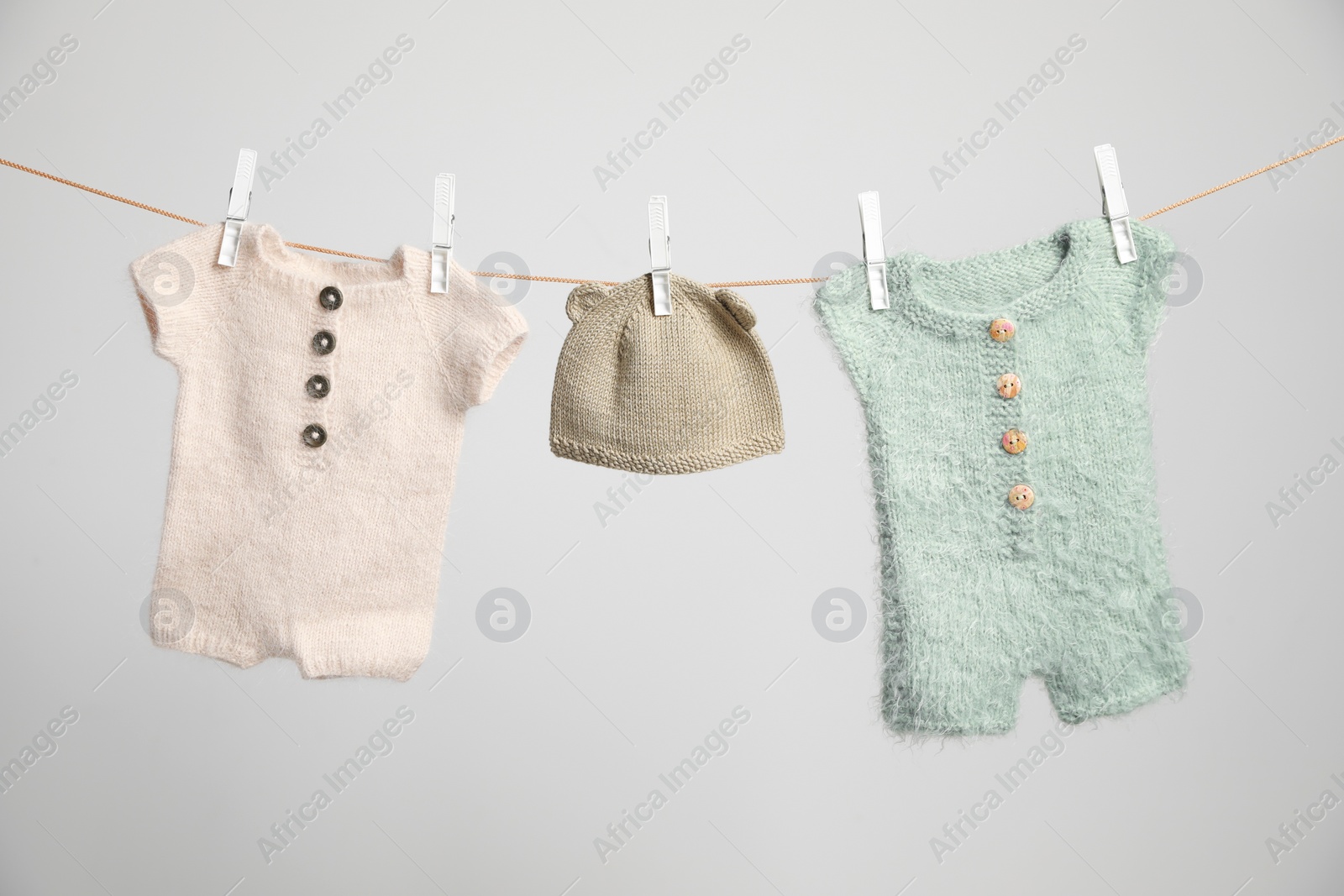 Photo of Baby clothes drying on washing line against white background